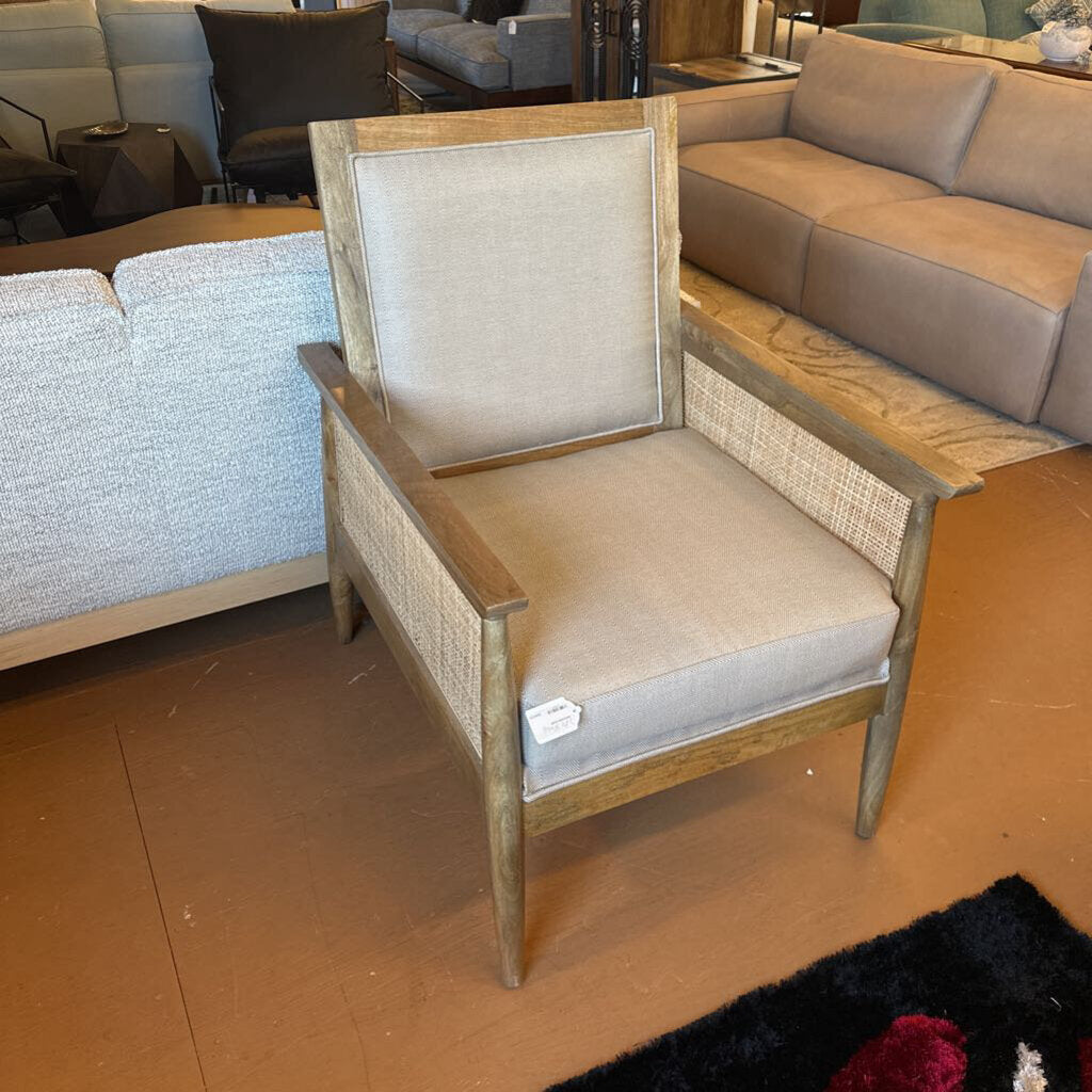 Wooden armchair with beige cushion in a room with furniture