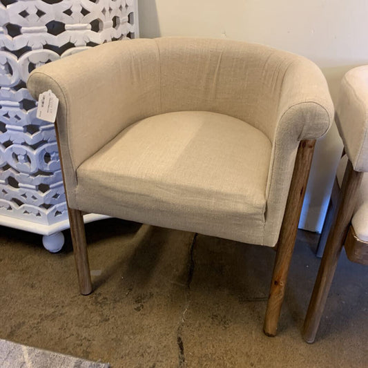 Beige armchair with wooden legs in a store setting