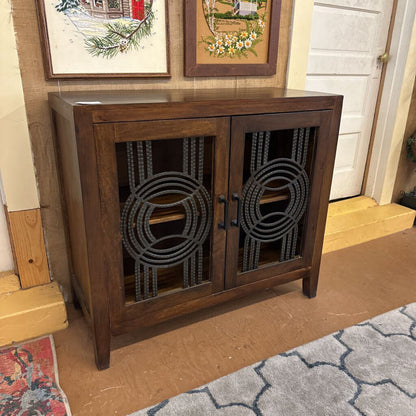 Wooden cabinet with decorative metal accents in a room setting