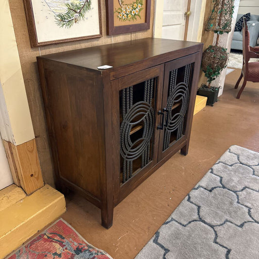 Wooden cabinet with decorative glass panels in a home setting