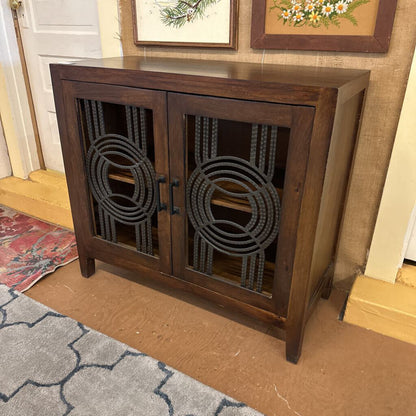 Wooden cabinet with decorative metal grilles in a room setting
