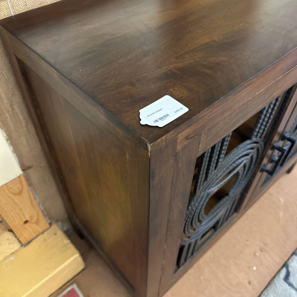 Wooden cabinet with a label on a tiled floor