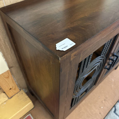 Wooden cabinet with a label on a tiled floor