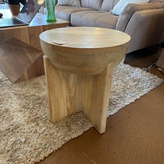Wooden side table in a living room setting with a laptop on a coffee table.
