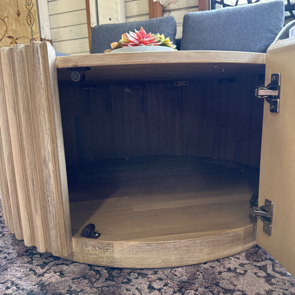 Wooden cabinet with open door on a patterned surface