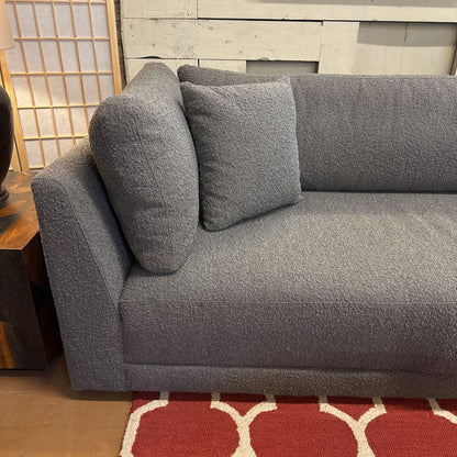 Gray sofa with cushions on a red and white patterned rug