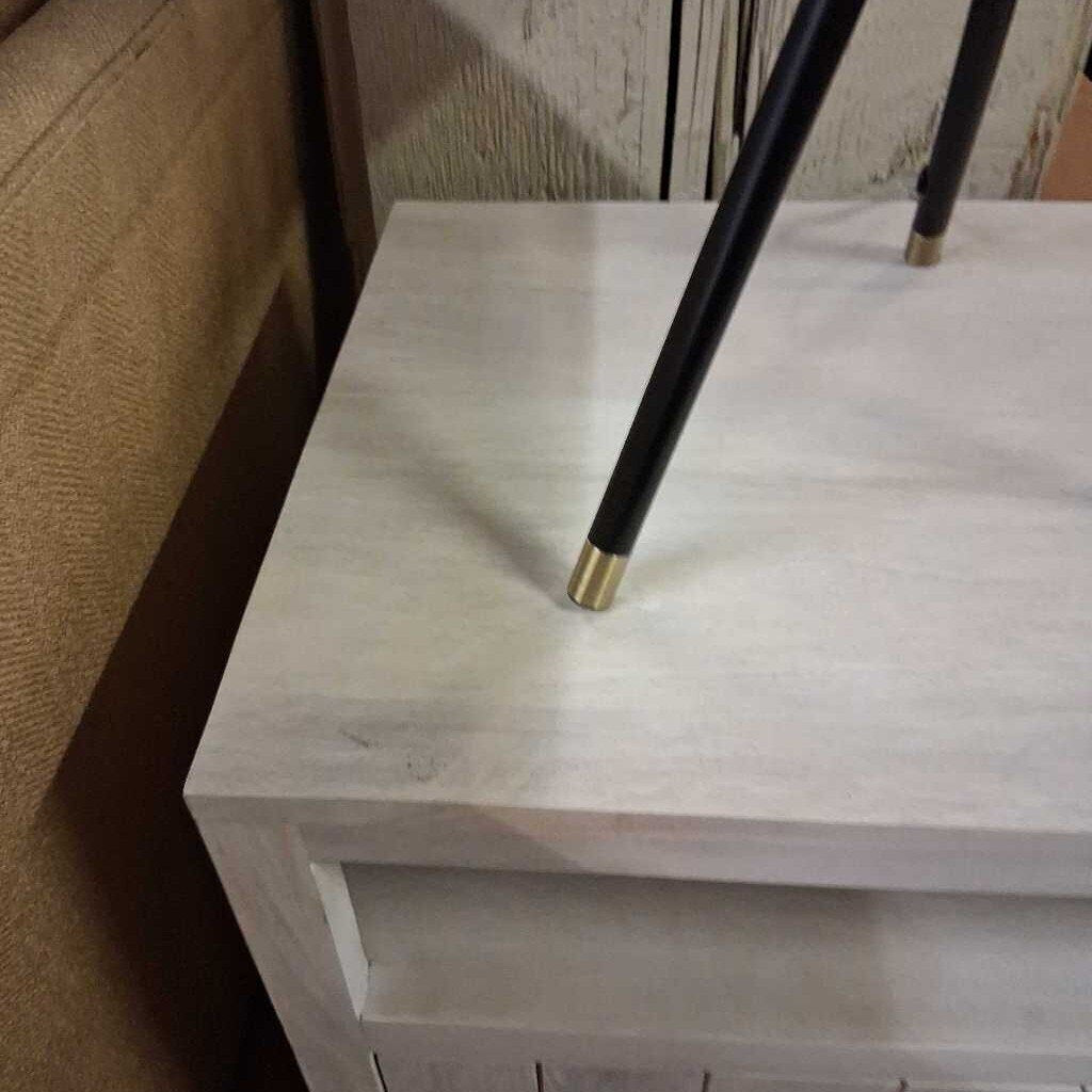 Black umbrella with gold tip on a white surface