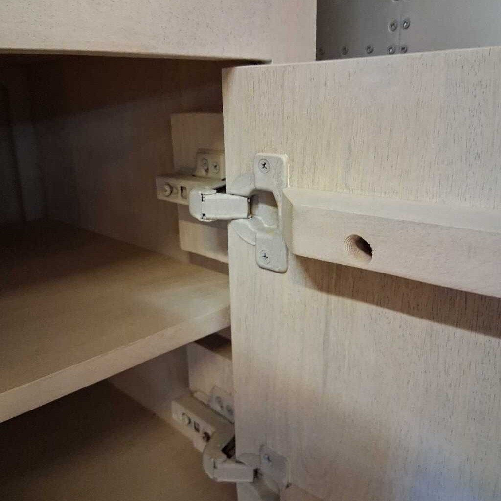 Close-up of a wooden cabinet with a hinge mechanism.