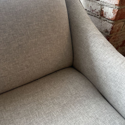 Gray sofa corner with a brick wall background