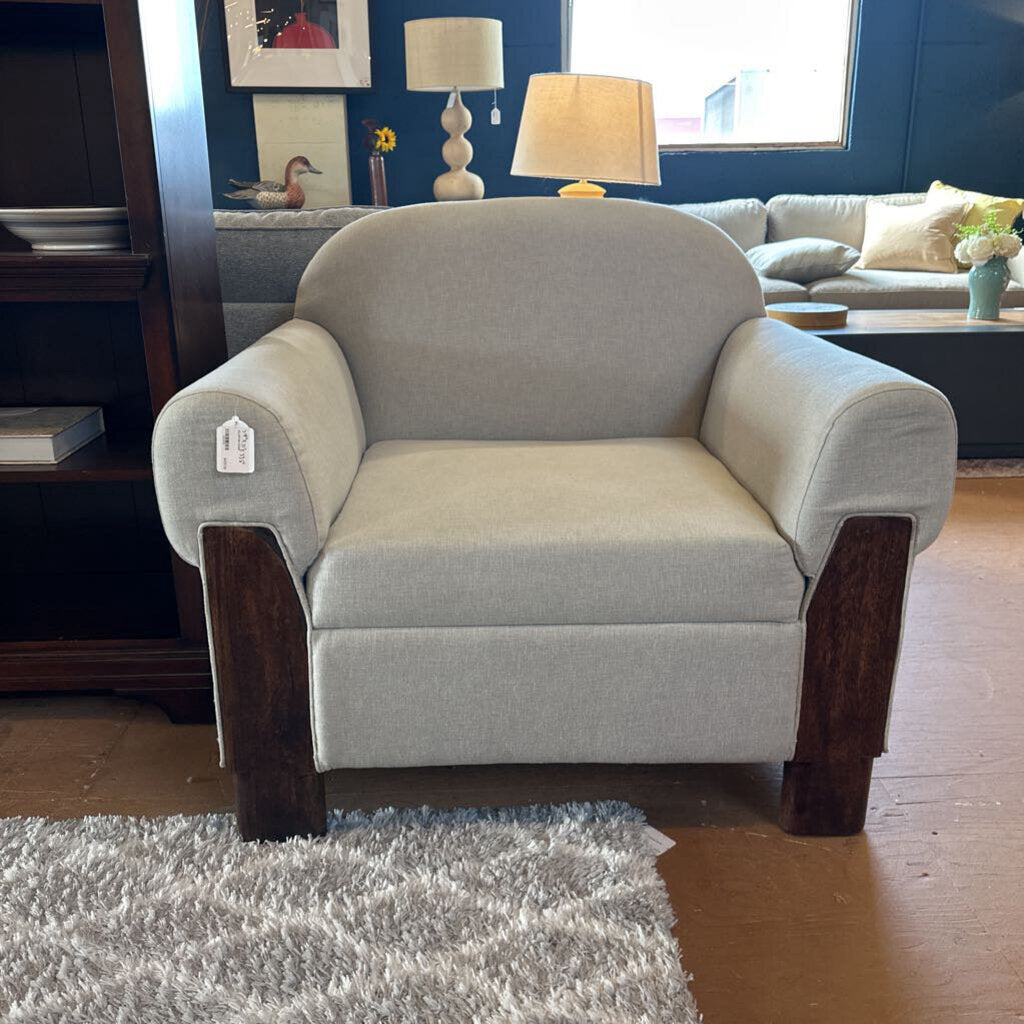 Gray armchair with wooden legs in a living room setting