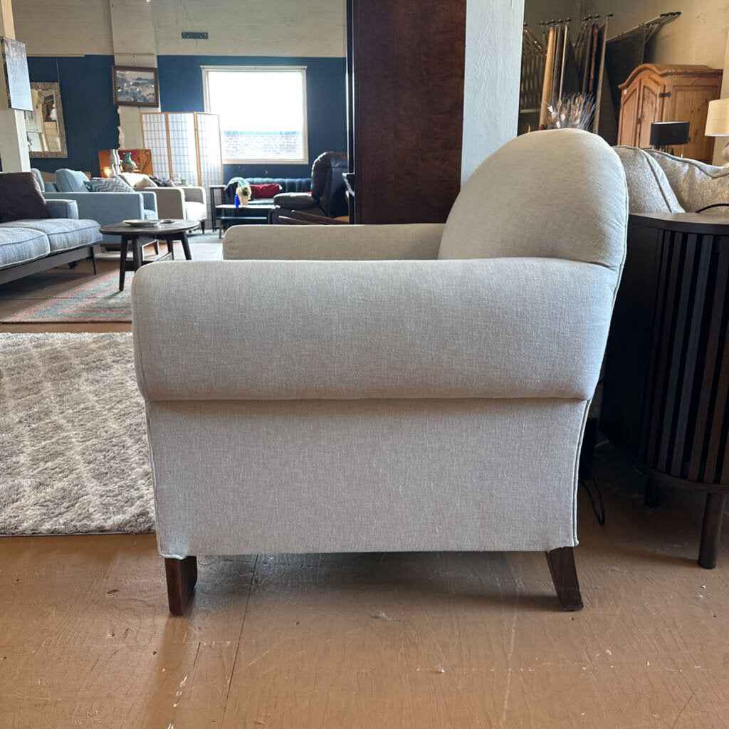 Gray armchair in a room with furniture and decor