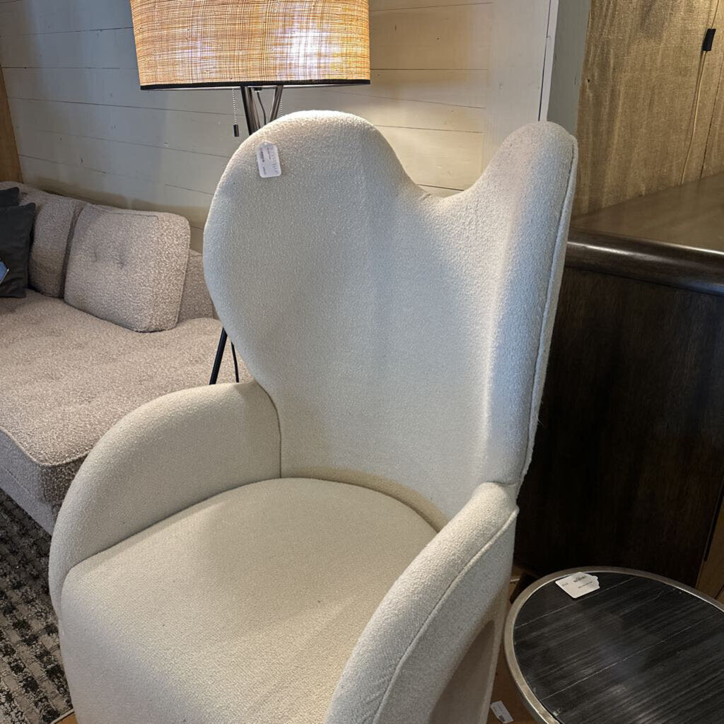 Beige armchair in a room with a lamp and sofa