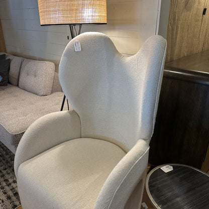 Beige armchair in a room with a lamp and sofa