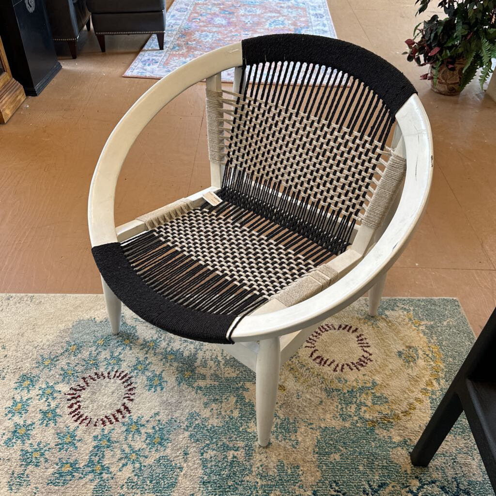 Chair with black woven backrest and seat on a patterned rug