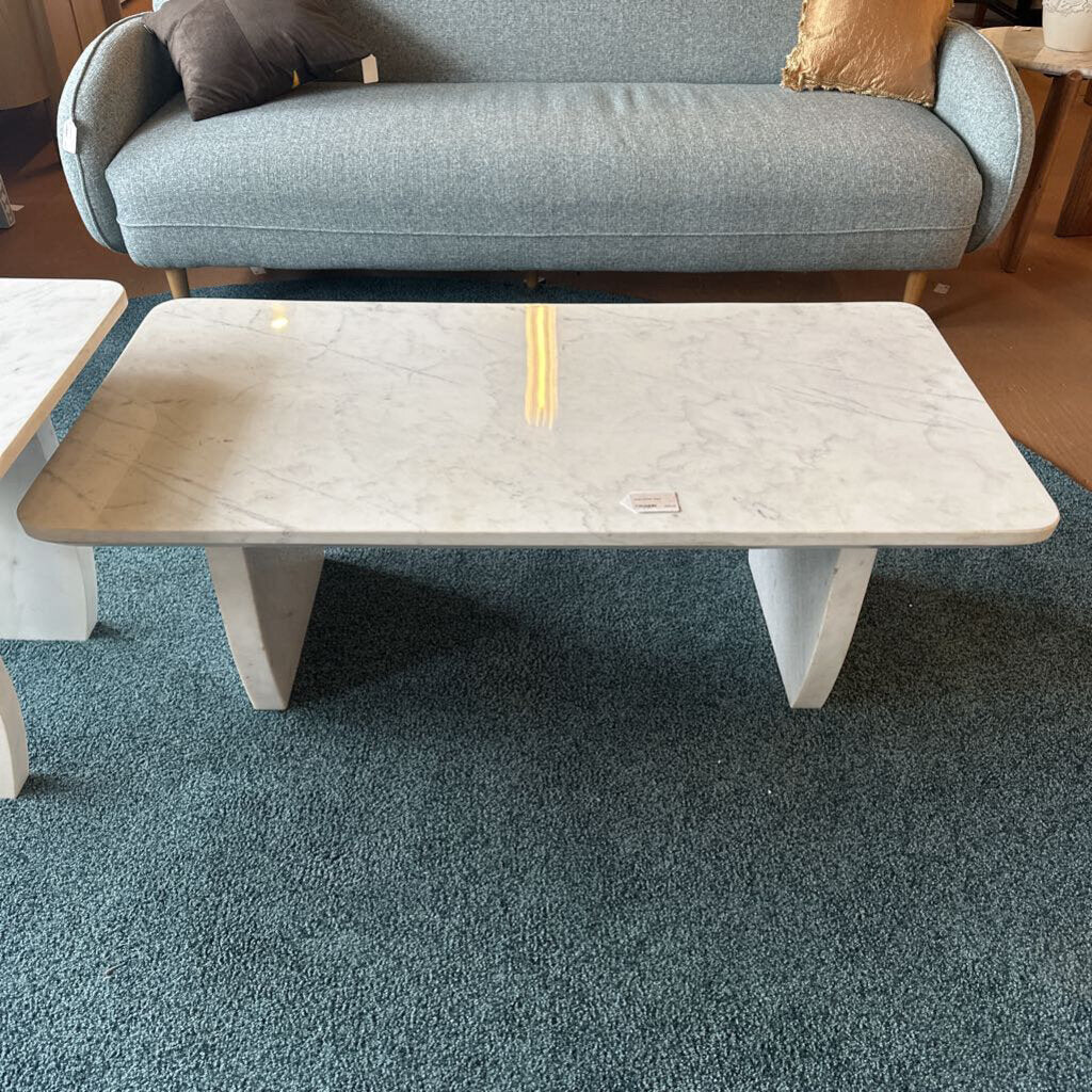 Marble-patterned coffee table in a room with a gray sofa and wooden floor.
