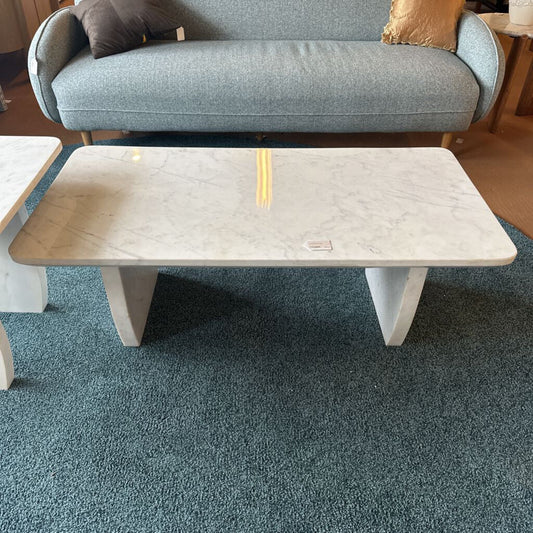 Marble-patterned coffee table in a room with a gray sofa and wooden floor.