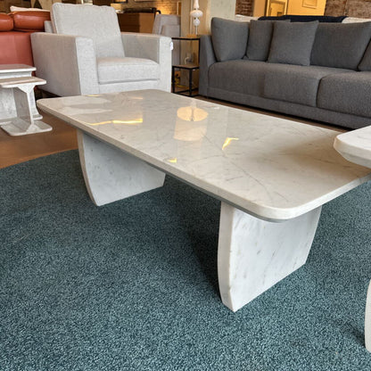 Modern marble coffee table in a living room setting with furniture.