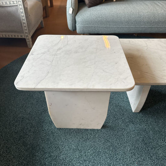 Coffee table with marble-like top and wooden sides in a room with furniture.