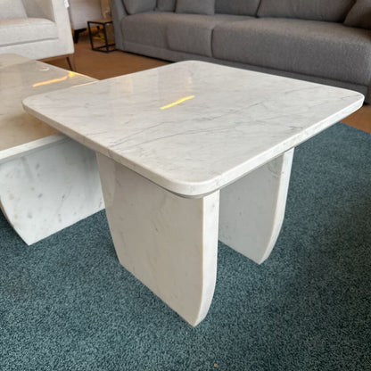 White marble coffee table in a living room setting with gray sofa and chairs.