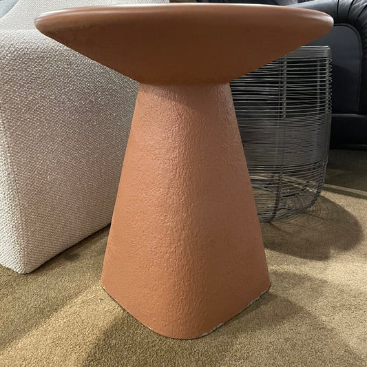 pale orange textured side table in a room with furniture