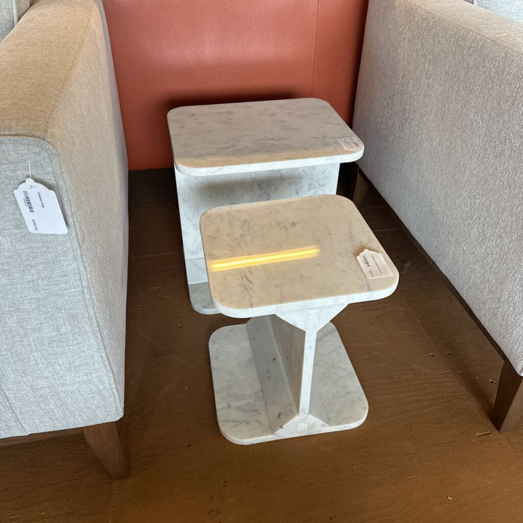 Two-tiered wooden step stool against a sofa with a visible price tag.