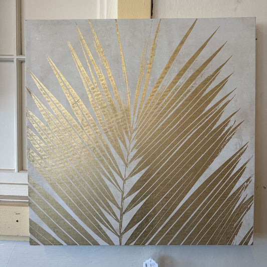 Decorative wall art with gold palm leaf design on a neutral background