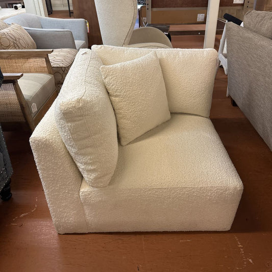 Beige textured sofa with cushions in a furniture store setting