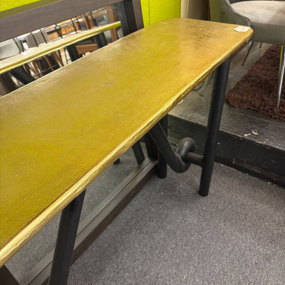 Yellow table with black legs on a gray floor