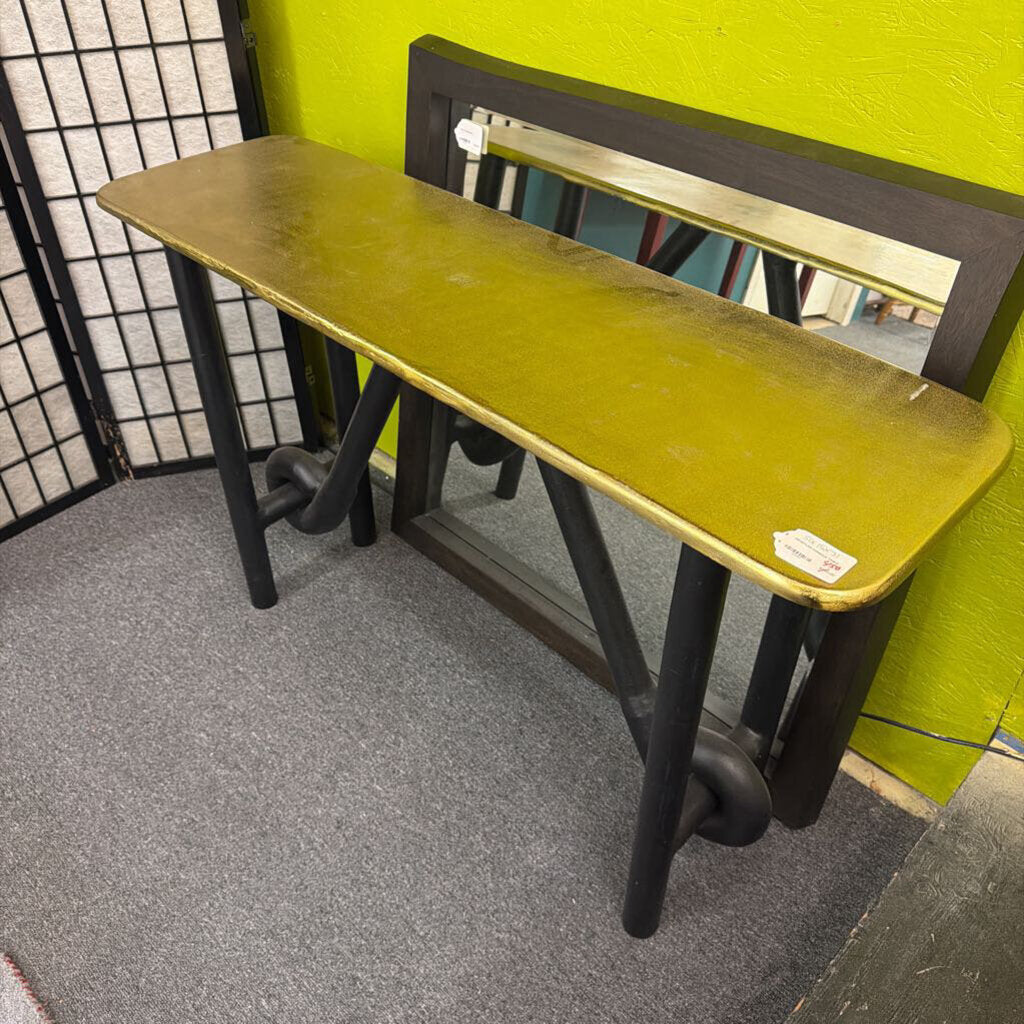 Green table with black legs against a green wall