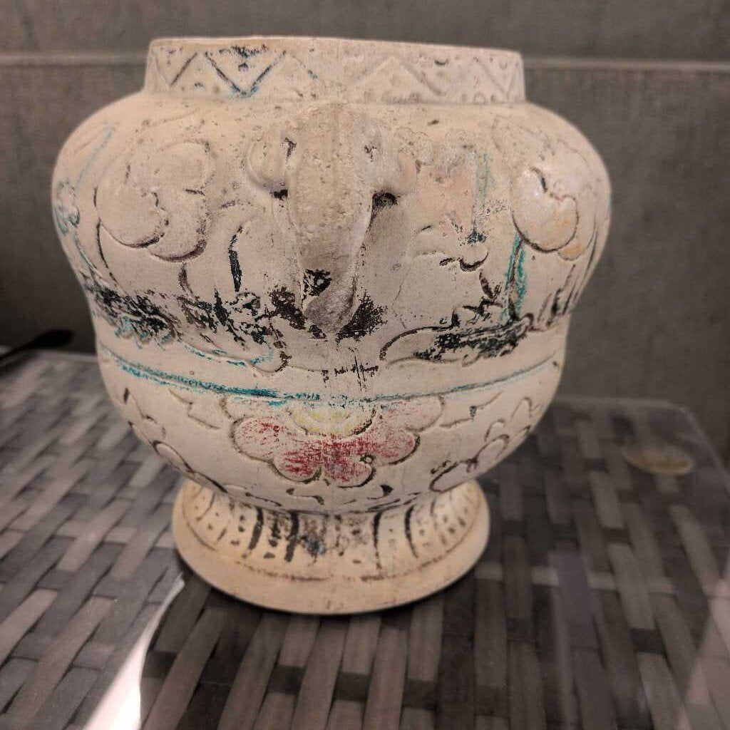 Decorative ceramic vase with intricate patterns on a textured surface