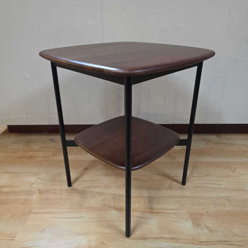 Wooden side table with two shelves on a wooden floor.