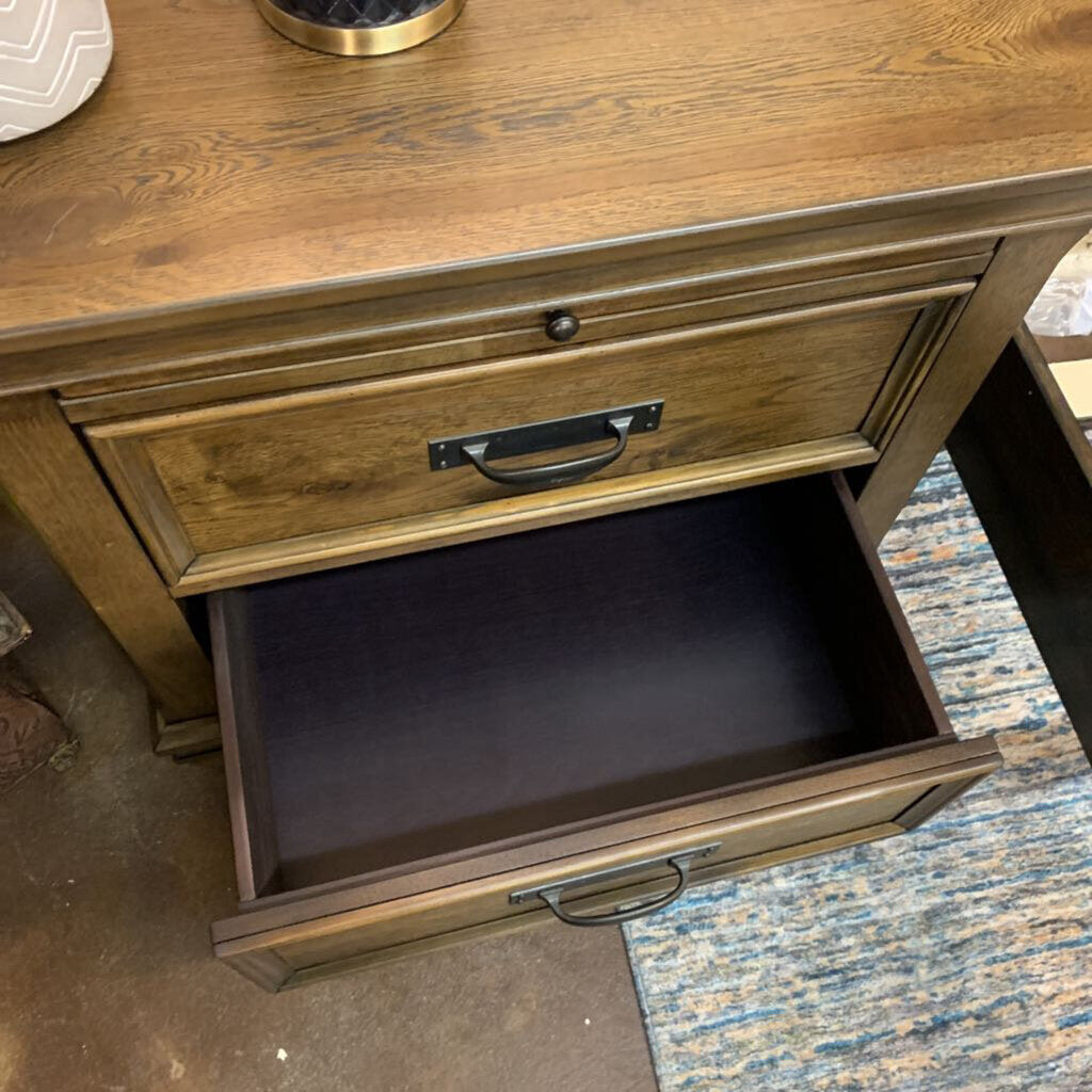 Wooden drawer unit with an open drawer on a carpeted floor.