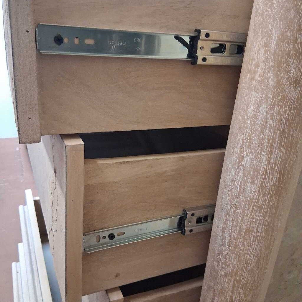 Wooden furniture with metal drawer slides on a blurred background