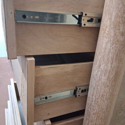 Wooden furniture with metal drawer slides on a blurred background