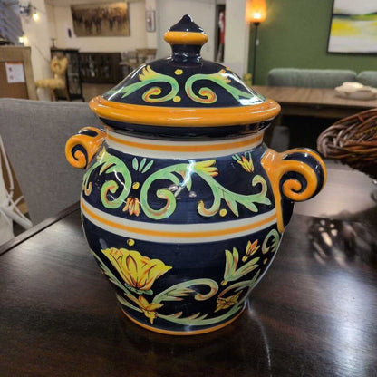 Decorative ceramic jar with floral patterns on a wooden table