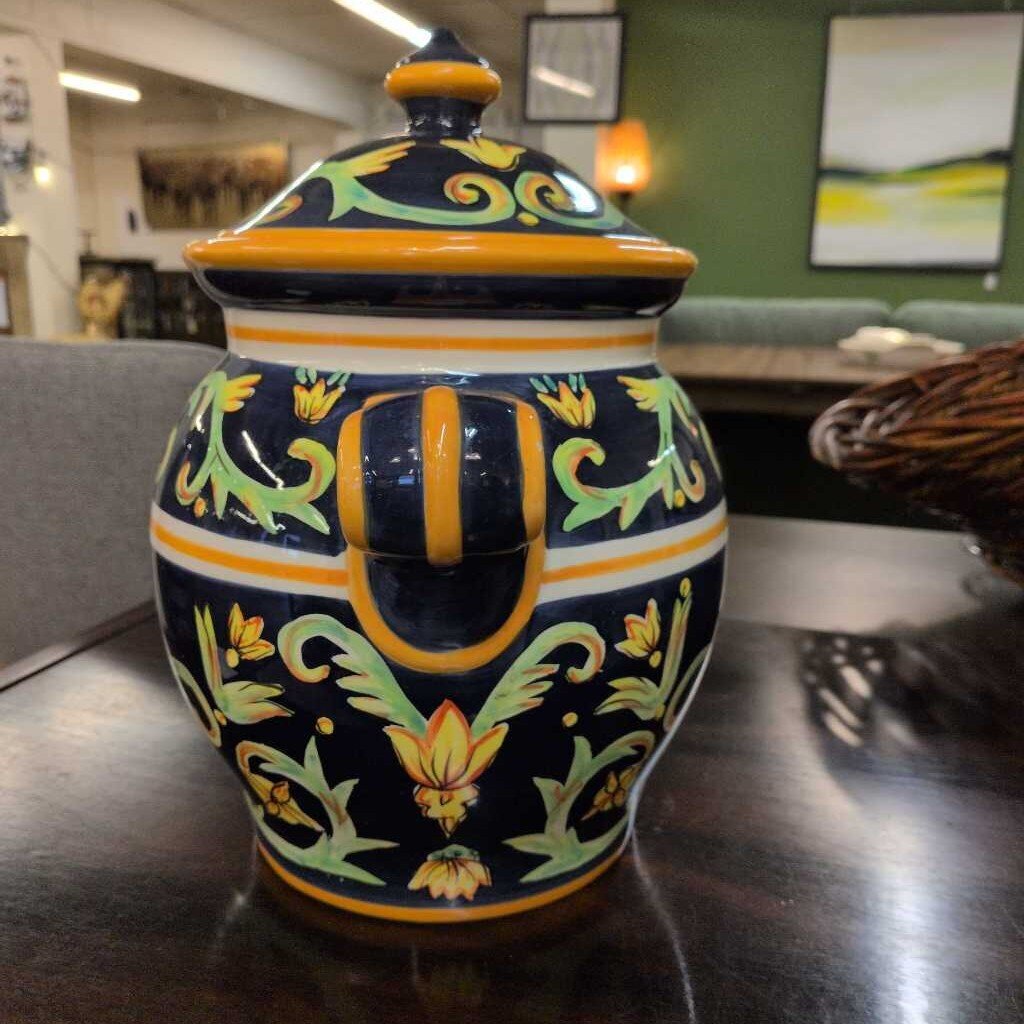 Decorative ceramic jar with colorful patterns on a wooden surface