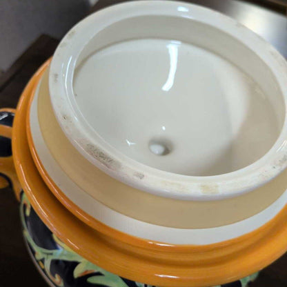 Close-up of a ceramic jar with a white lid on a dark surface