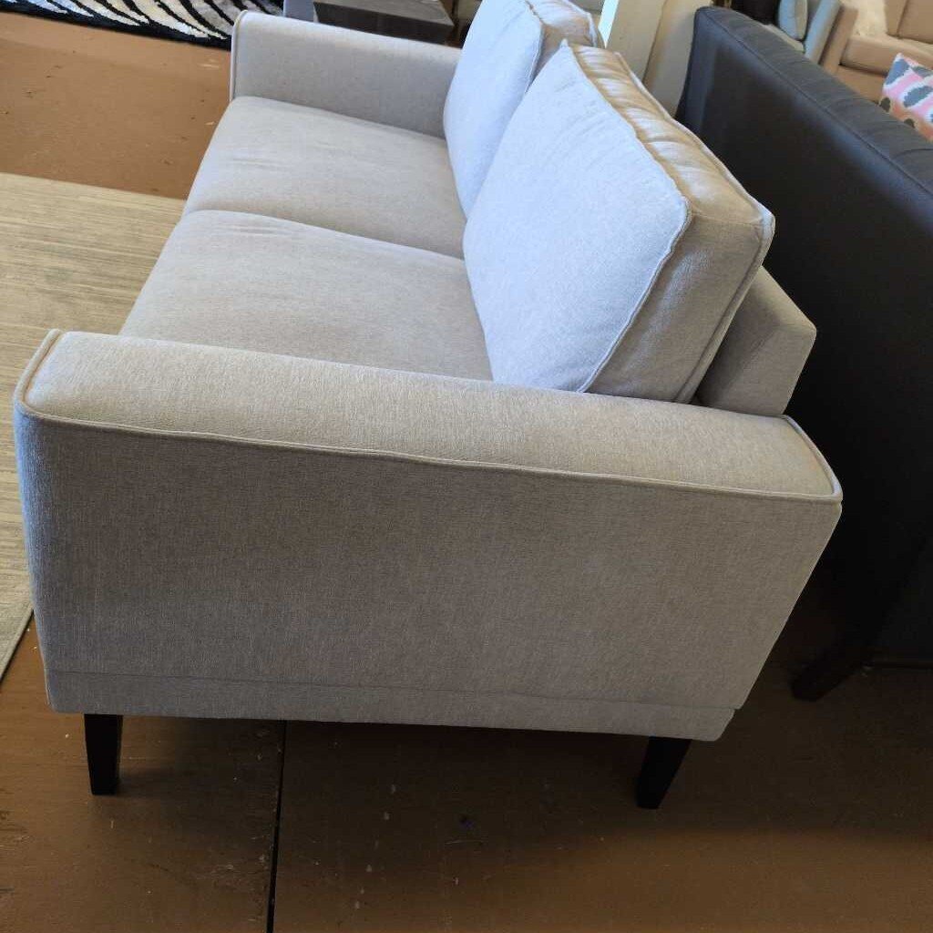 Beige sofa with cushions in a room setting