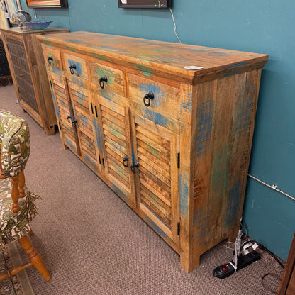 Wooden sideboard with a distressed finish in a room with a blue wall.