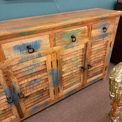 Rustic wooden cabinet with distressed finish and black handles on a carpeted floor.