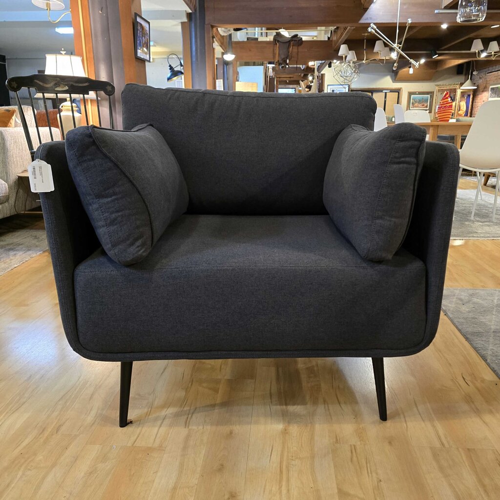 Gray sofa with cushions on a wooden floor in a showroom setting