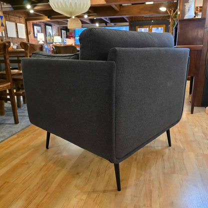 Gray armchair on a wooden floor with a restaurant interior in the background
