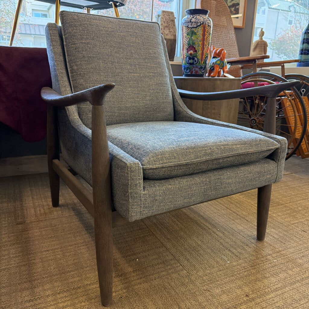 Gray armchair with wooden arms and legs in a room setting