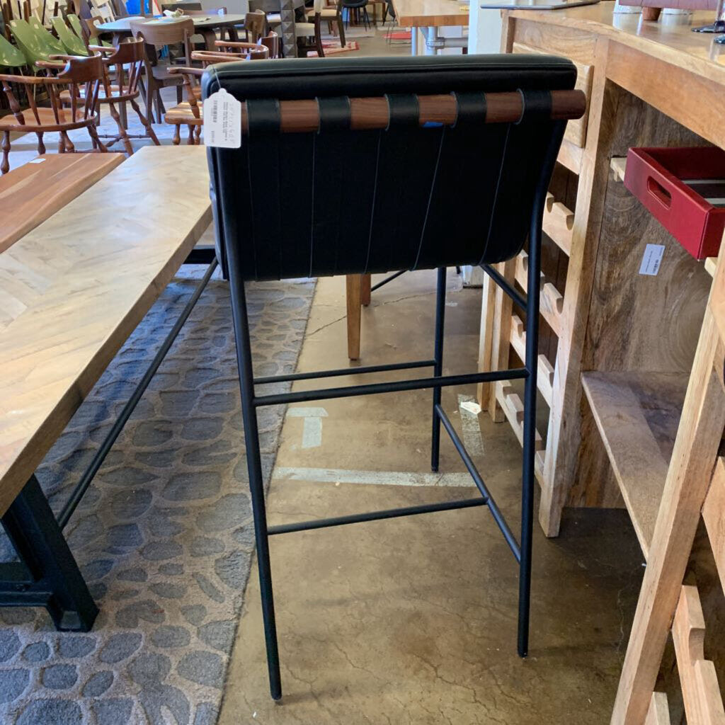 Black bar stool with brown accents in a store setting