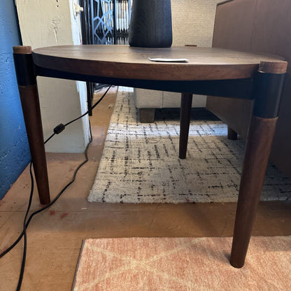 Wooden table with black legs on a wooden floor with a rug