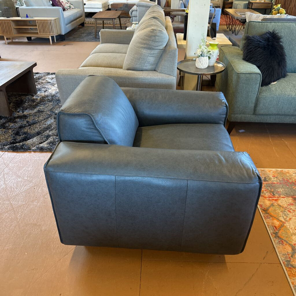 Gray sectional sofa in a living room setting with other furniture.
