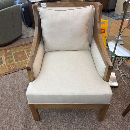 Chair with beige cushion and wooden frame in a room setting