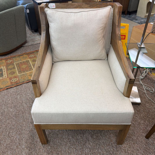 Chair with beige cushion and wooden frame in a room setting