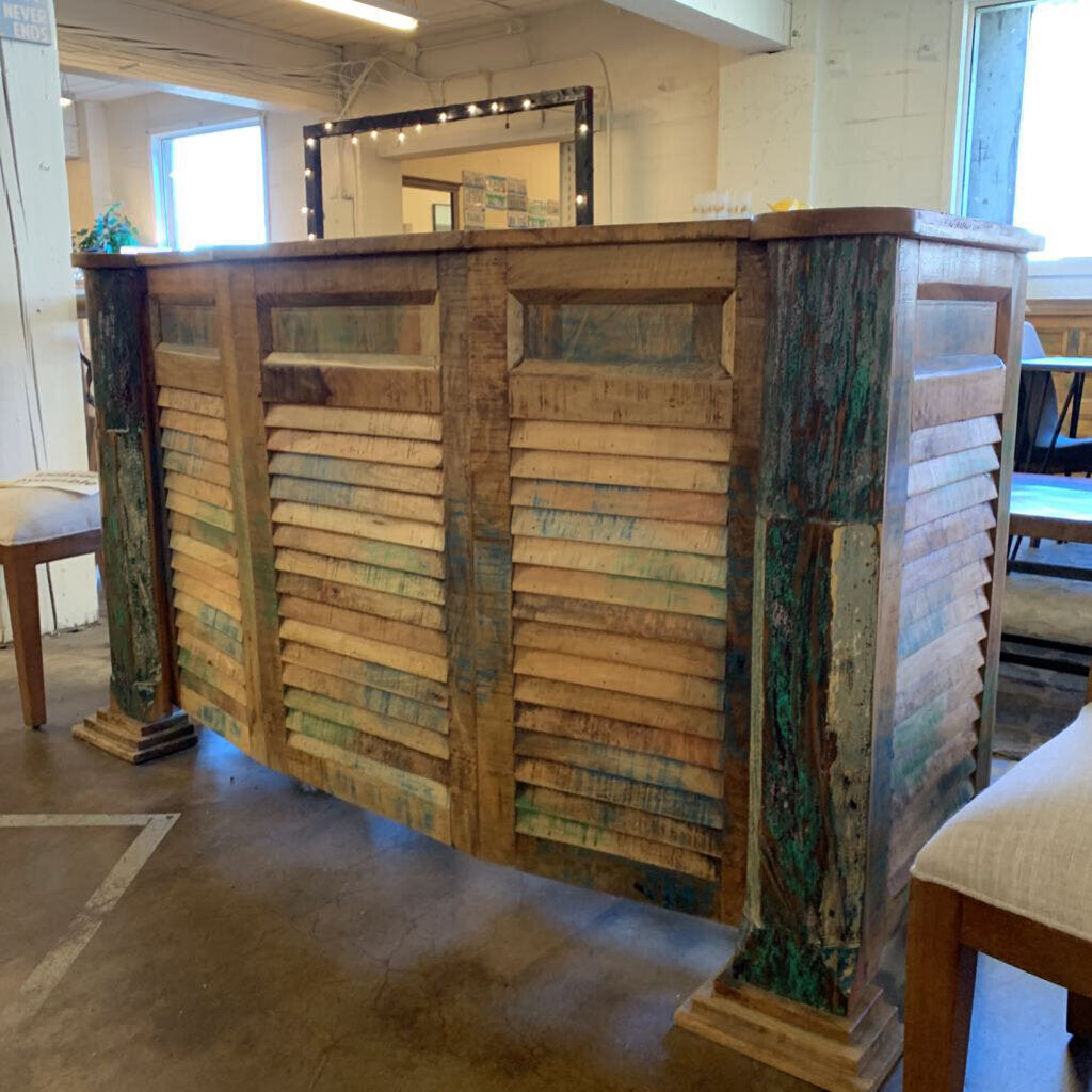 Reclaimed wood bar in a room with chairs and a mirror.