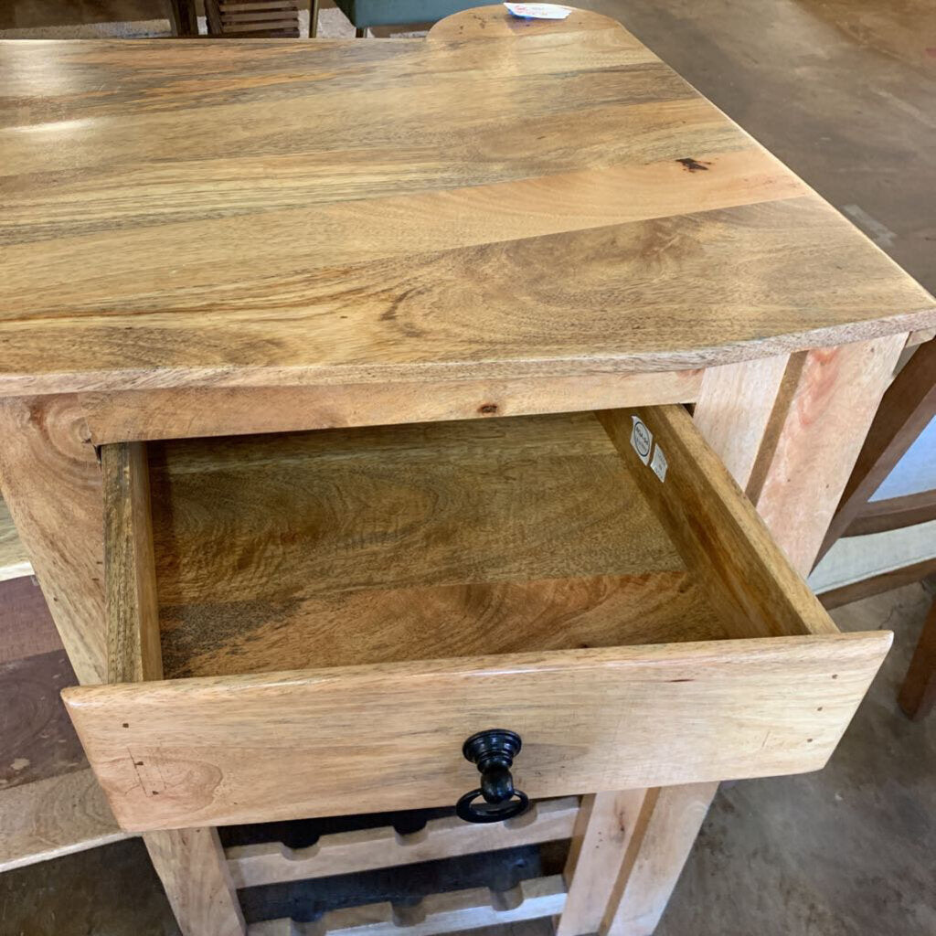 Wooden side table with a drawer in a workshop setting